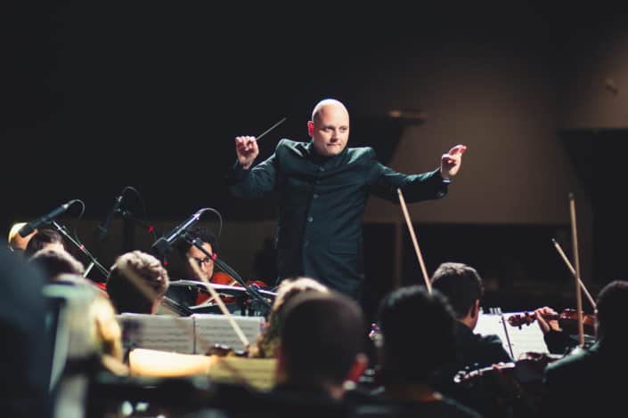 What is the name given to the person who directs the orchestra? Answer: Conductor.jpg