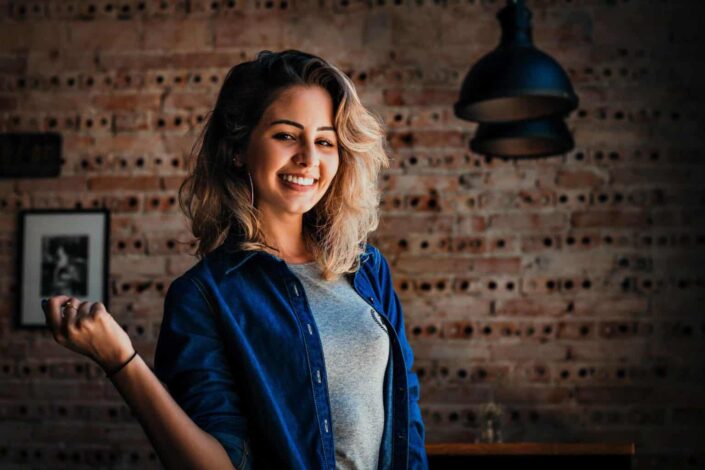 A smiling young woman in a blue denim jacket