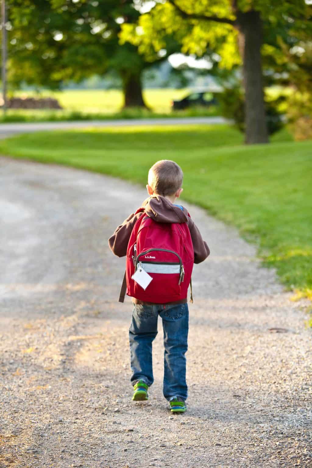 kid with a red backpack walking