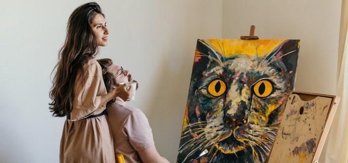 couple looking at painting of cat
