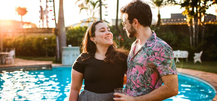 couple smiling at each other by the pool