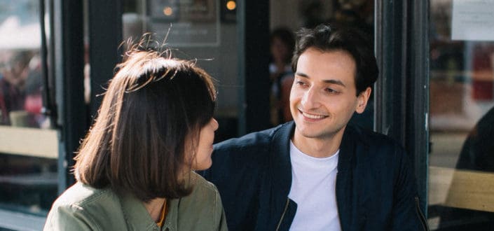 Guy smiling while talking to a girl.