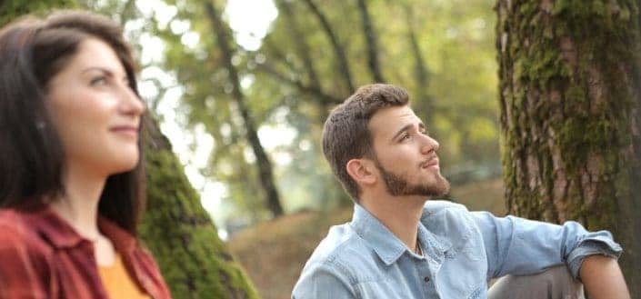 Guy and a girl, looking up on something.