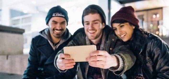 Three friends taking a selfie together.