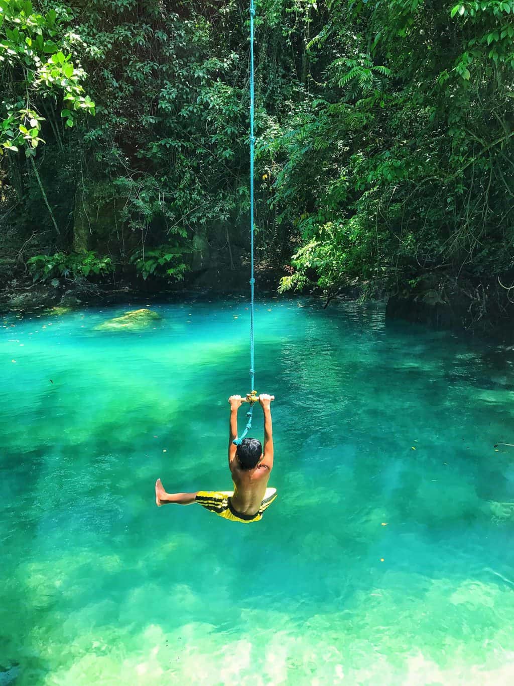 kid swinging in the river