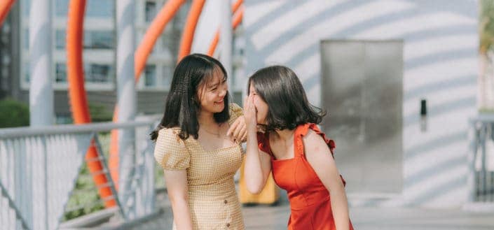 Two girls, laughing with each other.