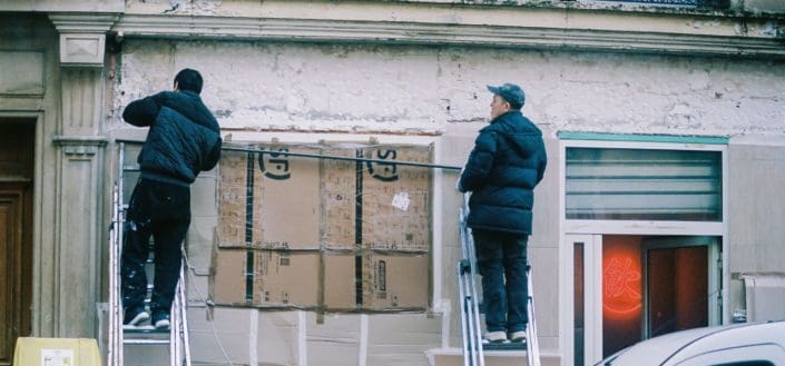 Two men fixing house exterior