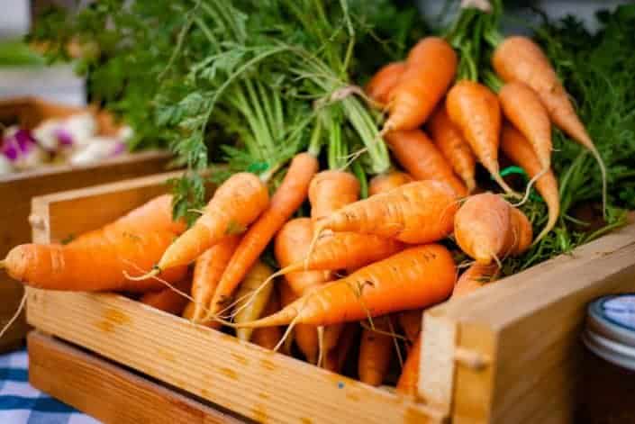 bunch of carrots on a wooden box
