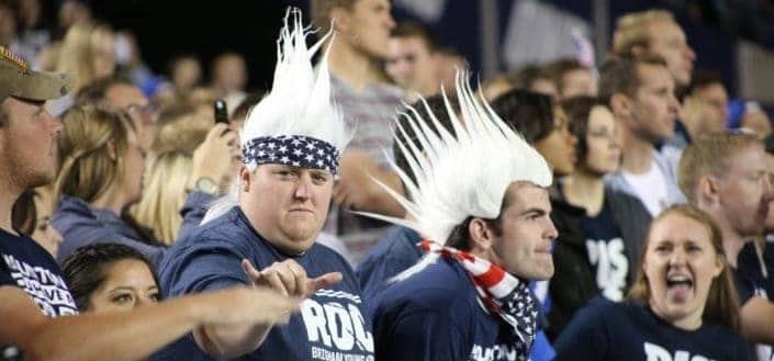two football fans with a trolls-like white hair among the crowd