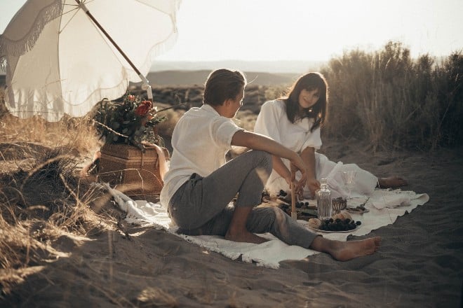 young-couple-having-picnic-on-sandy-beach- First date conversation starter - main