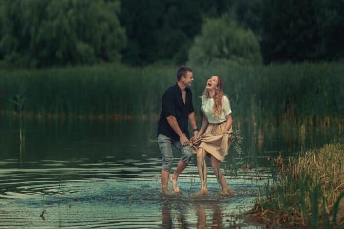 couple-walking-through-shallow-water-laughing-pexels