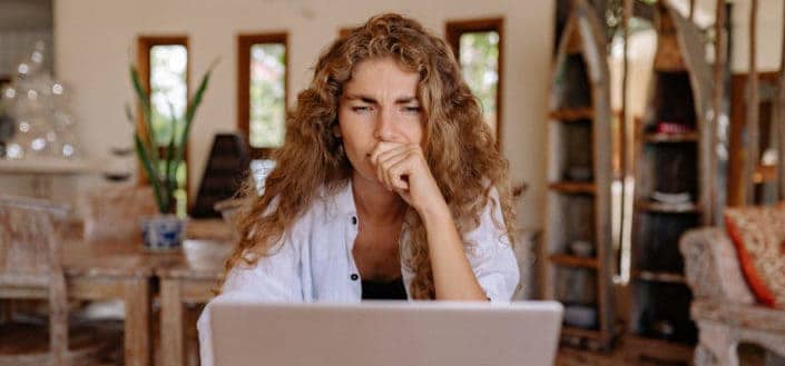 A girl thinking in front of laptop