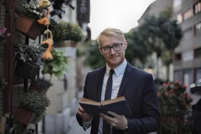 Man in suit holding a book
