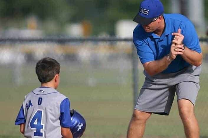 Coach Teaching Baseball to a Boy