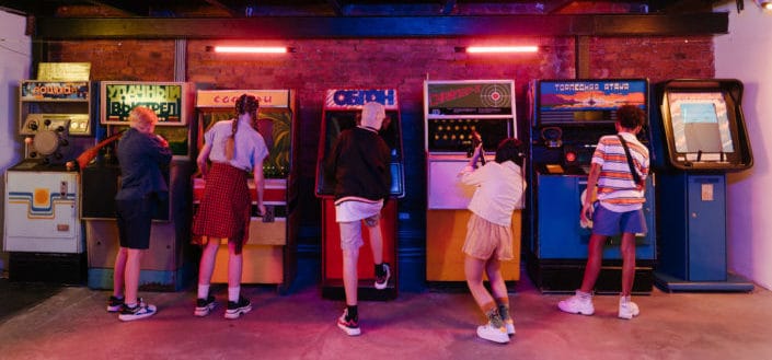 group of friends playing arcade