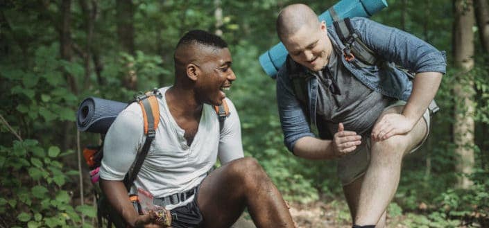 Cheerful multiethnic hikers resting in forest