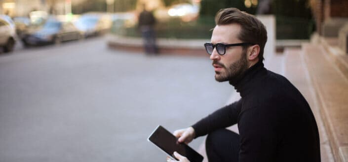 A man holding a phone and thinking.