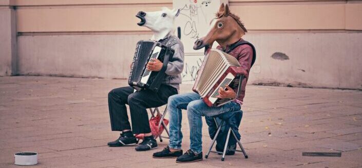 persons wearing horse heads sitting on folding chairs