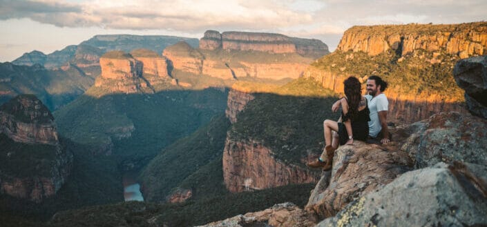 couple atop a hill overlooking landscape