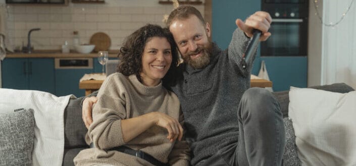 couple sitting with man pointing somewhere