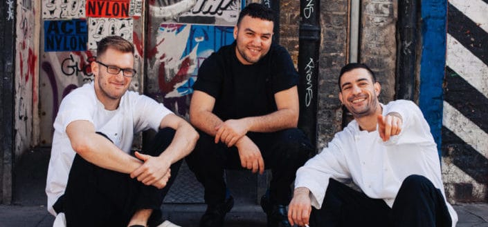 men smiling while posing for a picture