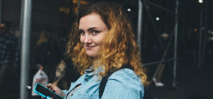 Girl with curly red hair smiling.