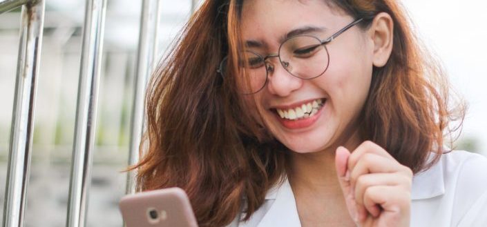 happy young woman wearing a white top 