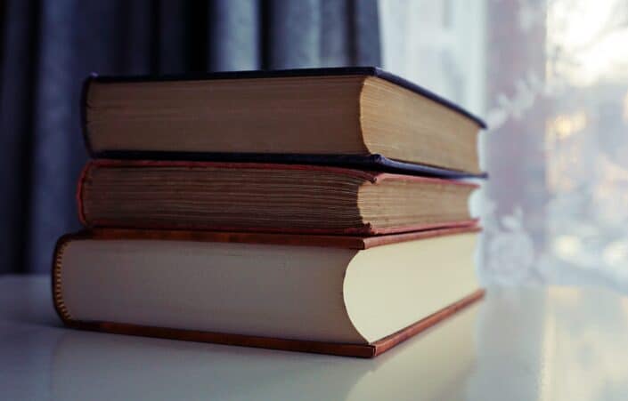 Three books stacked on top of a table