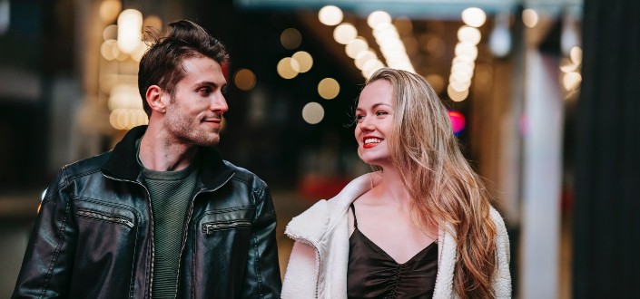 man wearing jacket looking at smiling woman