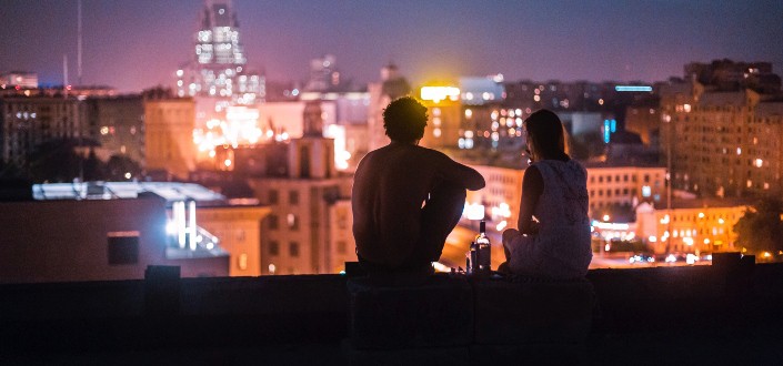 couple on rooftop looking at city lights