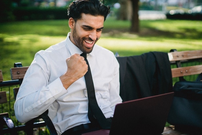 man smiling widely with his fist slighty up