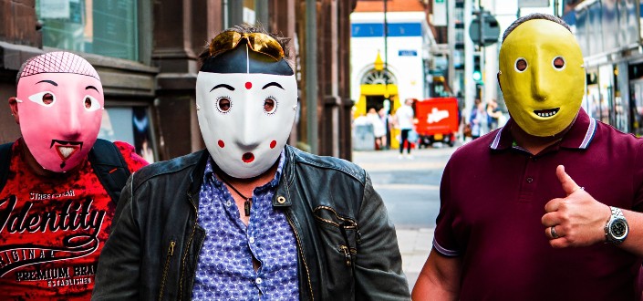 3 people wearing pink, white and yellow masks