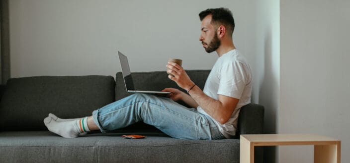 A man sitting on his couch while working