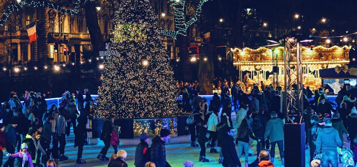 people skating around a christmas tree