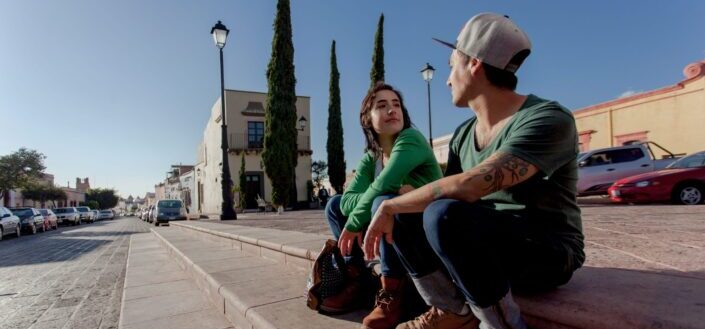 Man and woman sitting in the street talking to each other