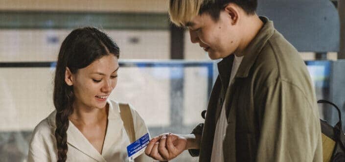 a woman and a man smiling at a coupon that the man is holding