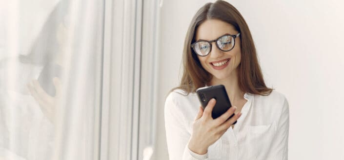 smiling woman looking at her phone