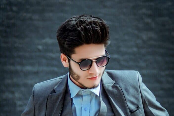 A young guy in grey suit wearing sunglasses