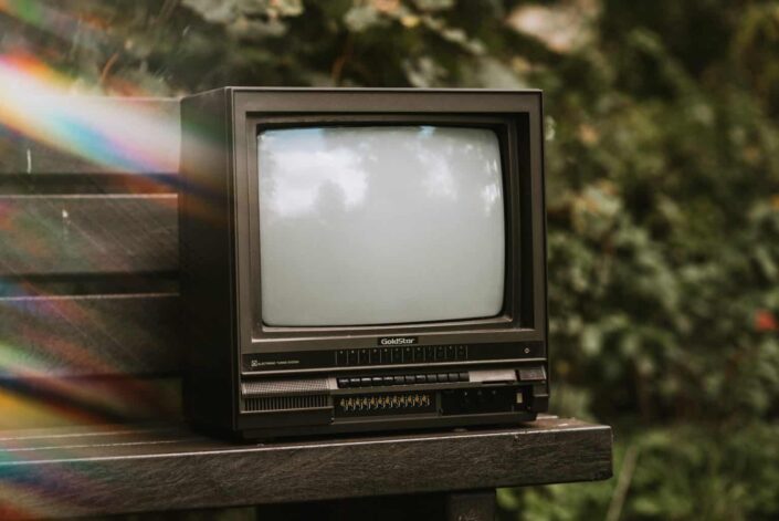 an old television placed on an outdoor bench