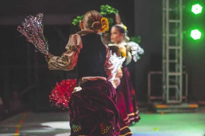 Girls dancing on a stage with flowers on hand