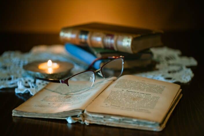 Open book with pair of glasses on top