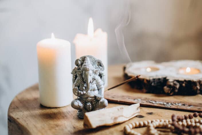 lighted candles, woods, and a metal elephant on table top