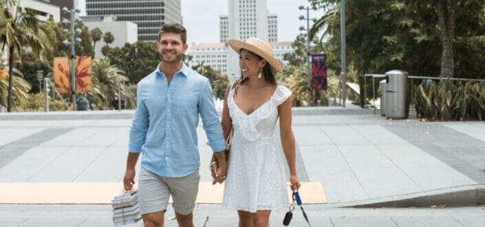 Couple holding hands and walking the dog