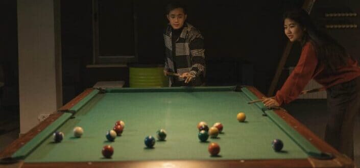 man and woman playing pool