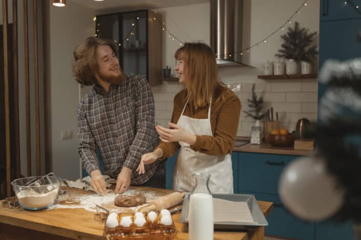 Couple having fun kneading some dough together.