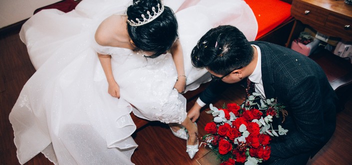 groom fixing the shoe of bride