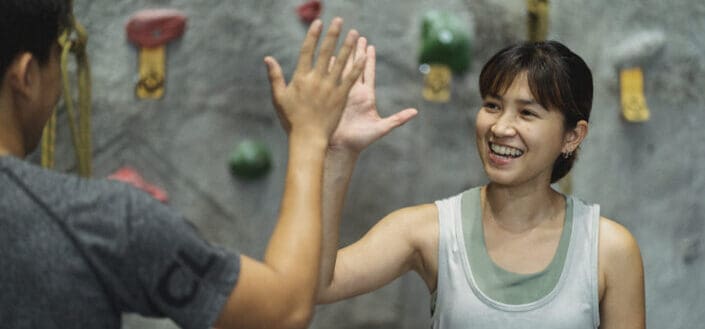 Happy climber and trainer giving high five