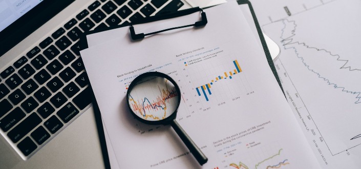 magnifying glass on top of a paper with graph