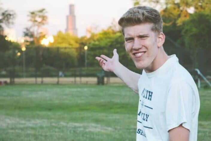 man in white crew neck t-shirt standing on green grass field during daytime