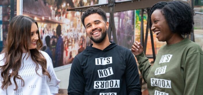 Two women smiling at a guy in between them